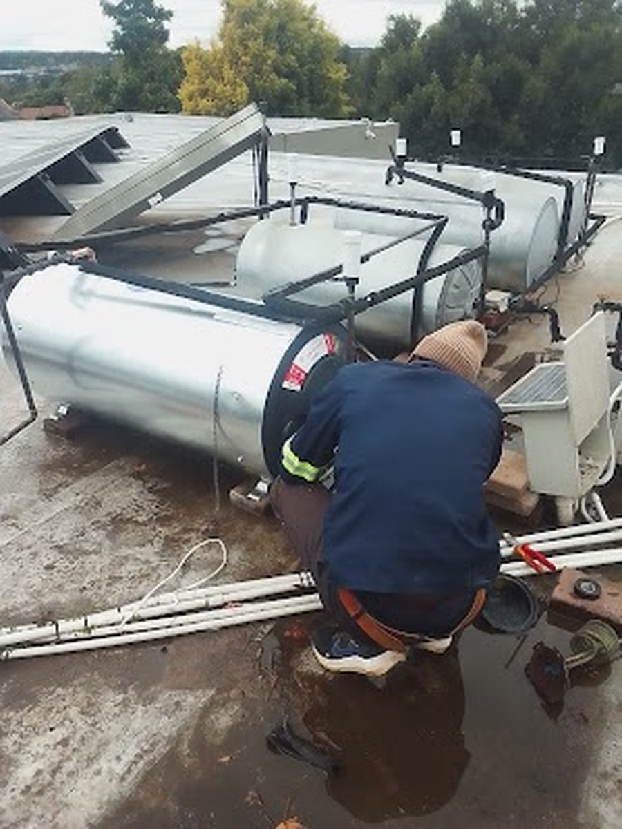 Plumber connecting geyser pipework on a Garsfontein roof
